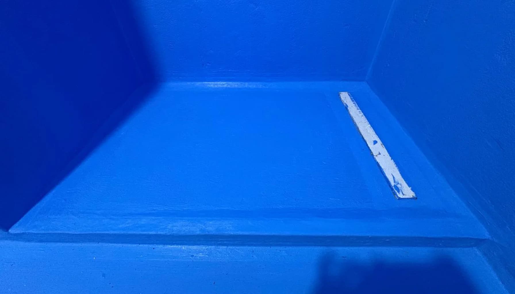 Санузел на стадии предчистовой отделки с подготовленными стенами, гидроизоляцией и линейным трапом